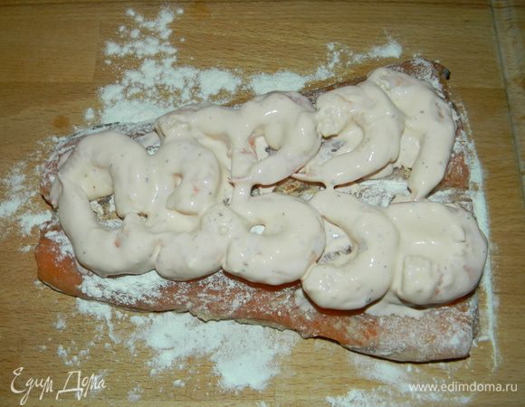 Креветки смешать со сметаной и томатным соусом, затем равномерно распределить креветки.