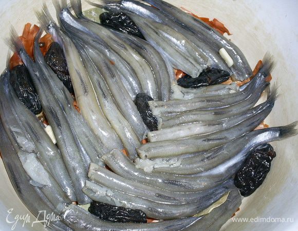 Затем плотно укладываем в кастрюльку мойву, спинками вверх, и чернослив. У меня получилось два слоя. Еще раз повторю: рыбку укладываем поплотнее!
