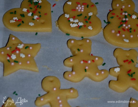 Вырежем формочками фигурки.Так чтоб между ними был расстояние. Украсим спринклс или крупным сахаром с корицей. Айсингом украшать нужно после их приготовления, как остынут. Бумагу с печеньями выложим на противень.И поставим в холодильник на 15 мин.Повторить также со второй частью теста.