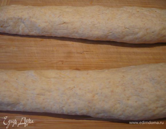 Делим тесто на две равные части. Одну часть делим на две равные части и выкладываем на рабочую поверхность (я делала косу на деревянной доске и мука для присыпки мне не понадобилась).   