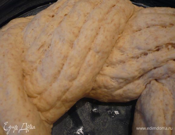 Скатываем из этих двух частей жгуты длиной примерно в 40 см, надрезаем каждую из них четыре раза вдоль и перекручиваем их вместе. Выкладываем в центр формы, заворачивая концы внутрь так, чтобы свободного пространства внутри косы не осталось.