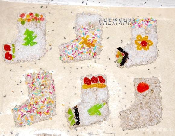 Итак, из сухофруктов (предварительно их промываем и даём подсохнуть) вырезаем то, что нам необходимо и немного вдавливаем, формируя узор. Кондитерскую посыпку и кокосовую стружку посыпаем на нужное место и немного прижимаем, остальное стряхиваем.