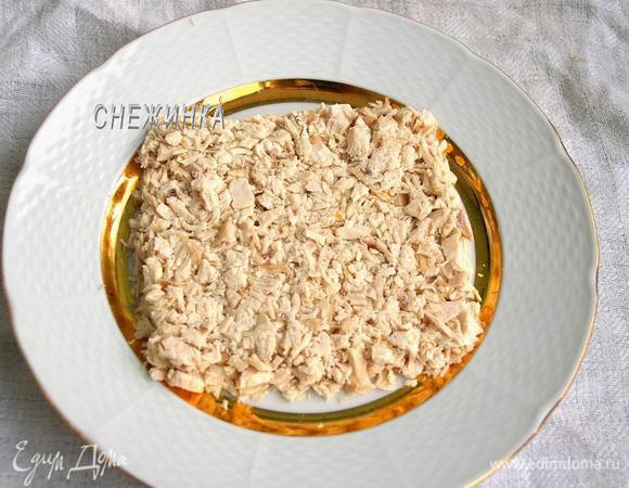 Курицу мелко нарезаем. Укладываем половину курицы на блюдо в виде квадрата. Хорошо утрамбовываем.