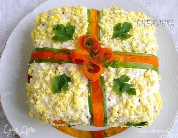 Для банта маленькие и тонкие лепестки моркови загибаем в виде петель. Из лука вырезаем тонкие полоски, они так же, как и ленты для украшения, при помощи ножа загибаются в завитки. Завиваем их и размещаем поверх банта. Всю остальную поверхность посыпаем растёртыми в крошку желтками.