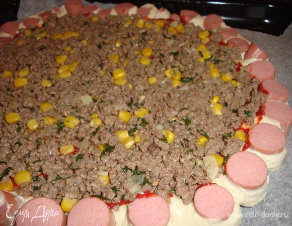  Делаем надрезы как на фото каждый 1-2 см, и разворачиваем сосиской кверху, в центр пиццы выкладываем начиночку.