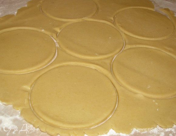 Смажьте сливочным маслом формочки для кексов. На присыпанной мукой поверхности раскатайте подготовленное тесто в тонки пласт 5 мм. Вырежьте из теста с помощью стакана или кондитерского кольца кружки чуть большего диаметра, чем формочки. 