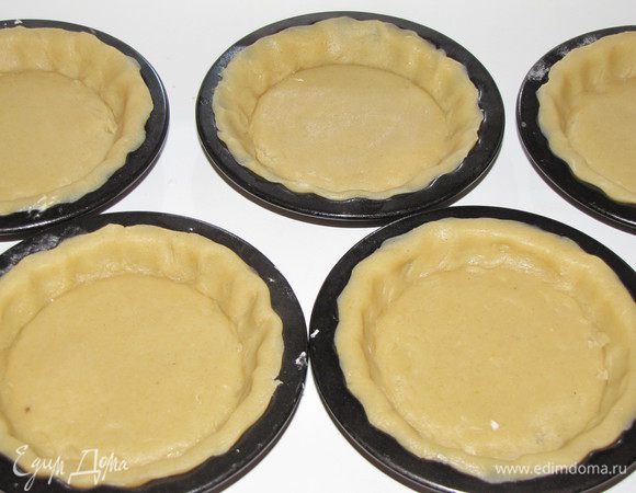 Уложите тесто в формочки и разровняйте, чтобы оно плотно село по форме, излишки срежьте. 