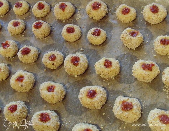 переложить на противень, в каждом шарике проделать углубление (я приспособила для этого дела футляр от ванильной палочки), наполнить отверстие желе. Выпекать в разогретой духовке при температуре 200° 10-12 мин.