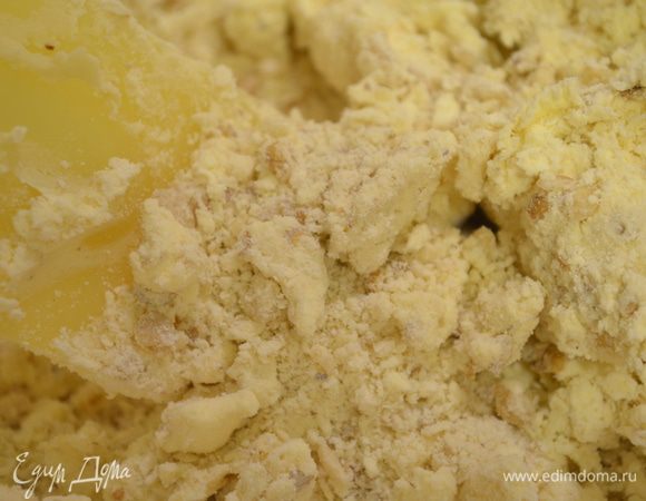 в масло ввести просеянную муку с разрыхлителем и орехи и растереть все. 