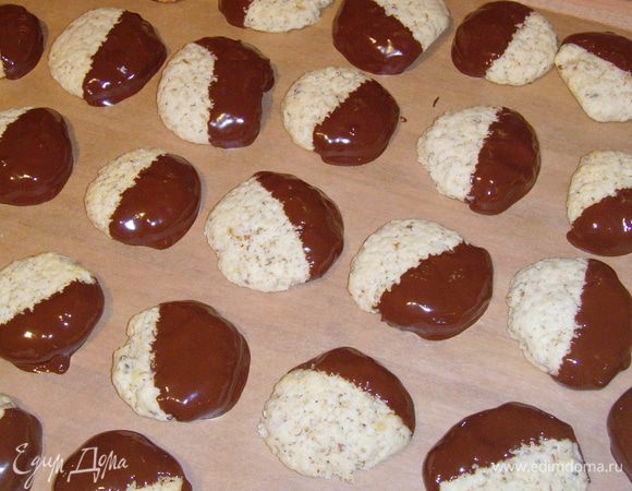 охлаждённые печеньки наполовину утопить в шоколаде, лишнему дать стечь, уложить для подсыхания на лист пекарской бумаги.