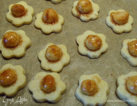 Тесто раскатать толщиной около 3 мм, формочкой выдавить заготовки (у меня цветочки) и перенести на подготовленный противень. В центре каждого печенья  расположить орех, немного его вдавливая в тесто. Выпекать в разогретой духовке при 180° 12-14 мин. Охладить.