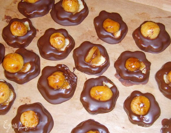 каждую печенюшку окунуть в шоколад, держа её за орех, дать лишнему стечь, поместить на пекарскую бумагу до полного высыхания.