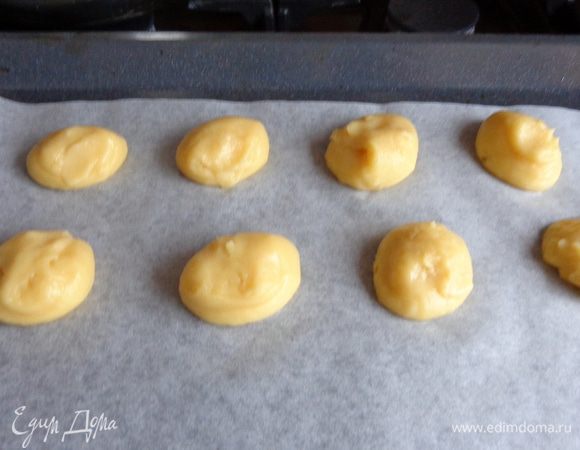 Оставшуюся часть заварного теста выложить в кондитерский мешок и выдавить 8 небольших шариков. Верхушки чуть приплюснуть. Выпекать так же, как и основу.
