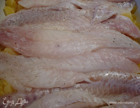 Выкладываем в форму картофель. На него обтертую кухонным полотенцем рыбу. 