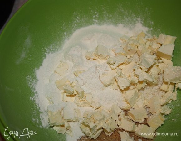 Туда же добавить порезанное на маленькие кусочки холодное сливочное масло и перетереть все в крошку.
