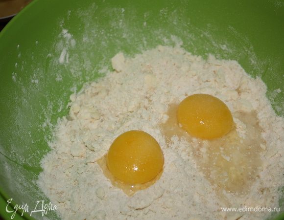 Добавить 2 желтка и 2 ст. л. ледяной воды и очень быстро перемешать,чтобы тесто собралось в шар (если будет очень сухое, добавьте еще ложку воды).