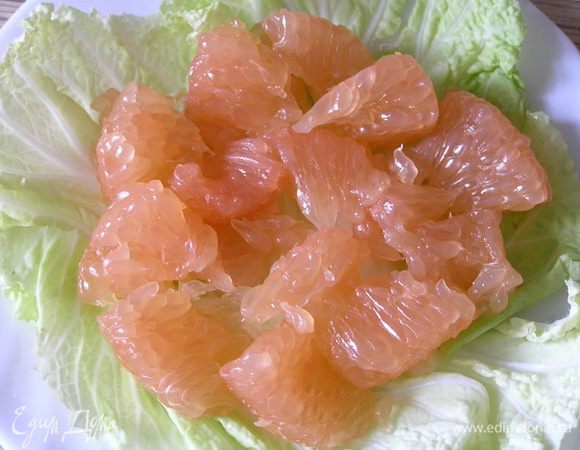Листья пекинской капусты разложить по тарелкам (по желанию можно порвать руками), выложить очищенные от пленок кусочки грейпфрута,