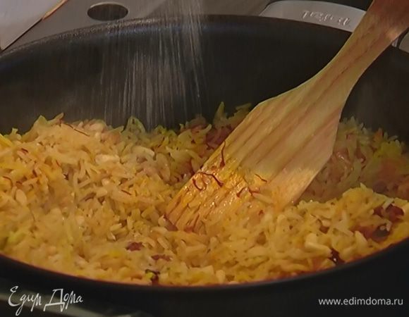Сотейник с пловом снять с огня, добавить кедровые орехи, посолить и перемешать.