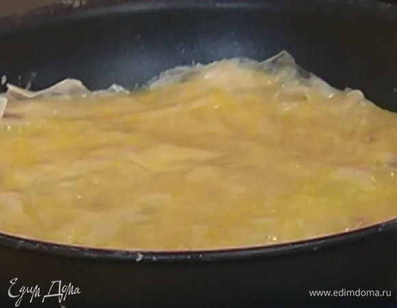 Из оставшегося пласта теста вырезать круг по размеру сковороды, накрыть им плов и смазать сверху маслом.