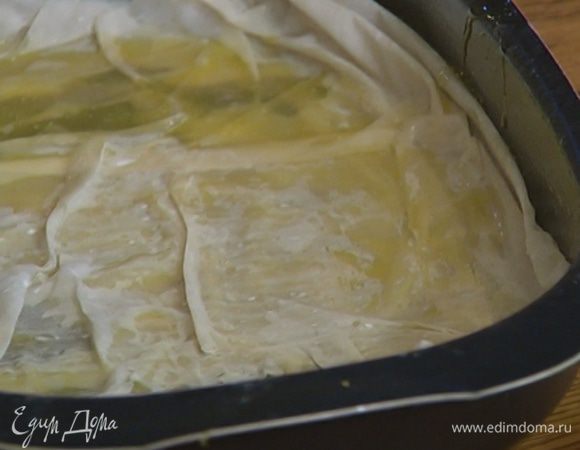Один пласт теста фило сложить пополам и выложить на дно формы, смазать сливочным маслом. Оставшиеся пласты теста разрезать пополам и, промазывая каждый слой маслом, уложить еще 8–10 слоев.