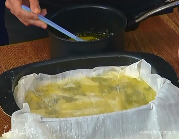 На тесто выложить апельсиново-фисташковую начинку, разровнять и накрыть сверху оставшимися пластами теста, смазывая каждый слой маслом.