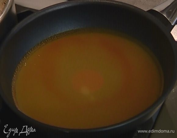 Сахар высыпать на сковороду, влить 200 мл воды, добавить апельсиновый экстракт и сварить сироп. 
