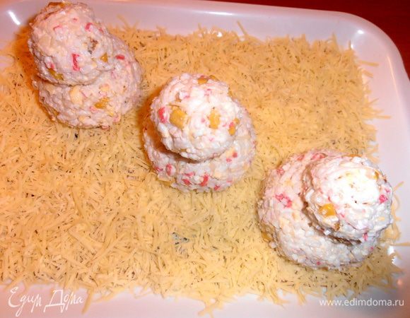 С помощью одноразовых перчаток начинаем"лепить комочки снега"из салата и аккуратно установим их друг на друга.