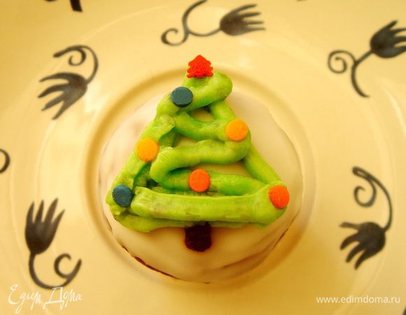 Для ёлочки смешать белый шоколад с зелёным красителем и нарисовать на помадке зелёный треугольник. Затем зигзагом "закрасить" ёлочку и украсить сахарным конфетти. Чёрным шоколадом нарисовать ствол. 