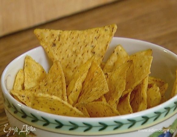 Кукурузные чипсы поломать руками на небольшие кусочки.