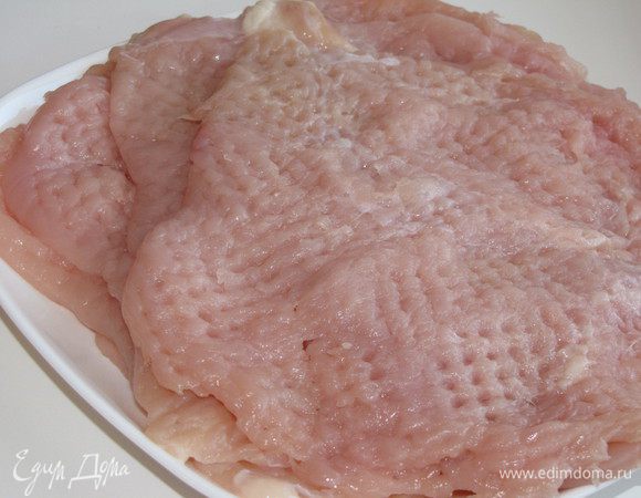 Куриное филе накрыть полиэтиленовой пленкой и хорошо отбить до толщины 4 - 5 мм.