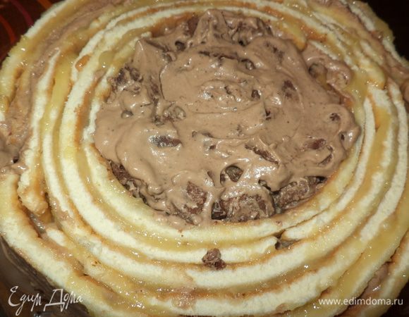 Приступаем к сборке. Первый корж обмазываем кремом.
Белый бисквит разворачиваем,убираем бумагу или коврик,можно это сделать раньше как только остынет и опять свернуть ,чтобы не терял форму круга,разрезать рулет на кусочки 2,5-3 см, разложить по длине и промазать хорошим слоем фруктового крема,Одну полосочку свернуть в кружок,,уложить на середину и вокруг обматать остальные полосочки.Ну вот тут случилось самое интересное,белого бисквита не хватило,я ведь в начале сделала ширину 5 см!!! и даже разрезав пополам-не хватает и тут  вспоминаю,что Тата обрезала бисквит по краю и облив шоколадом использовала на украшение!И вот оно решение проблемы:обрезав по краю 1 см я режу бисквит кубиками,смешиваю с кремом,а во второй торт я добавила еще и ложечку фруктового, вынимаю середину полосочек столько чтобы хватило обмотать до к рая и середину заполняю бисквитно-кремовой массой!Сверху крем,вторую половину коржа и обмазываем все остатками крема верх и бока,все хорошо разравнивая,выносим на холод.