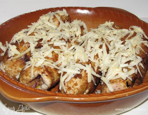 Выложить рулеты в жаропрочную форму, немного посыпать тертым сыром и довести до готовности в духовке.