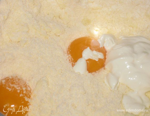 Добавляем желток, сметану и вымешиваем до однородности. Затем вливаем молоко и получаем мягкое, не прилипающее к рукам тесто. Если тесто получилось суховатым и крошащимся, добавьте молока. Убираем в холодильник на пол часа и начинаем заниматься начинкой.