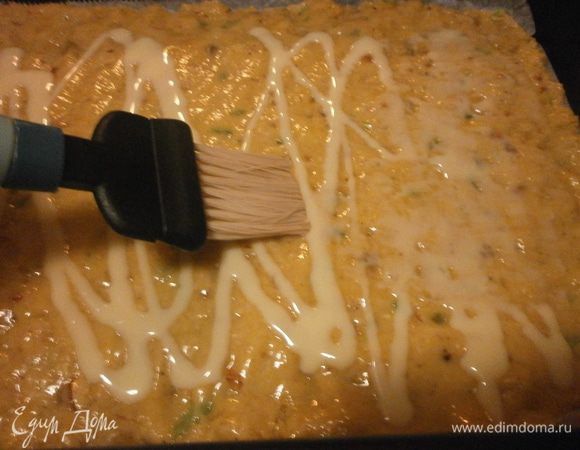 Листы застелить бумагой для выпечки, смазать сливочным маслом. Тесто разделить на две части и выложить на листы. Разровнять.Распределить равномерно кисточкой по поверхности сгущённое молоко.