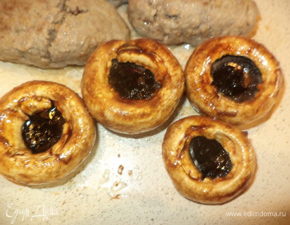 Нагреть сковороду, добавить немного масла, достать из маринада грибы и обжарить сначала «юбочку» гриба, перевернуть и влить наш маринад в каждую шляпку, готовить минут 7–10. У меня этот процесс проходил одновременно с колбасками с черносливом под крышкой, вроде они не ссорились!