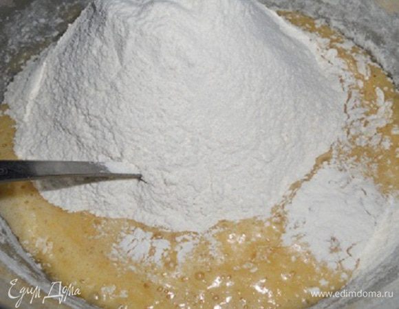 Всыпать муку (450 г) частями, добавить соль и соду и вымешать до однородности. Муки может пойти меньше или больше, ориентируйтесь по густоте.