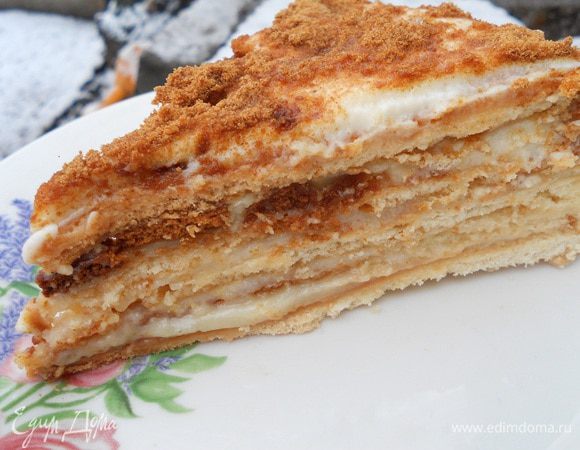 Взять остальную часть крема и взбить со сметаной,снять первый корж переложить на другое блюдо и промазать вторым кремом и так каждый корж перекладывая поочередно. Один из коржей перемолоть в кофемолке и обсыпать им вверх и бока торта, сверху также я посыпала сахарной пудрой. Торт поставить в холодильник на пропитку на пару часов, а лучше на ночь, тогда он просто божественный на вкус.