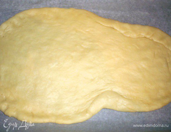 Приступаем непосредственно к формированию "поросенка". Оставляем кусочек теста размером со средний персик для оформления. Остальное делим на две почти одинаковые части. для нижнего слоя раскатываем меньшую часть овалом толщиной чуть меньше сантиметра. Намечаем голову будущего зверя.