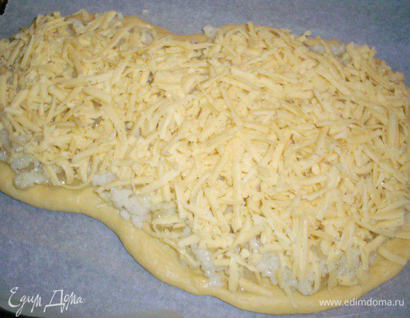 Выкладываем рисовую начинку (она не даст тесту намокнуть) и посыпаем тертым сыром.