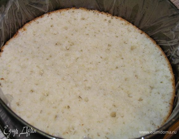 Форму застелить пищевой пленкой, выложить первый корж,