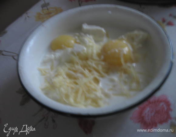 Сыр Фету выложить в миску, размять, добавить яйца и молоко, поперчить, добавить мускатный орех, сыр Пармезан натереть на терке и добавить в смесь. 