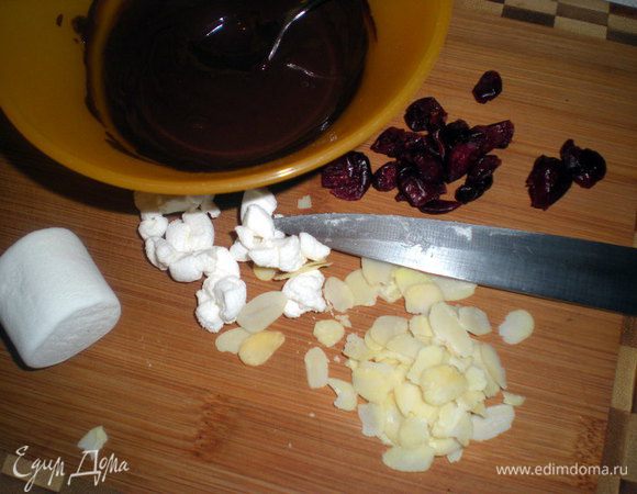 Растопить шоколад на водяной бане или в микроволновке. Маршмеллоу порубить, подготовить орехи и клюкву. Если клюква крупная, то тоже нарезать помельче.