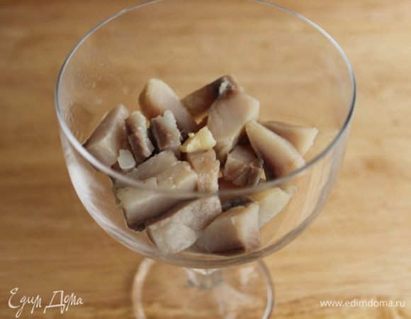 На дно бокала выложить сельдь....