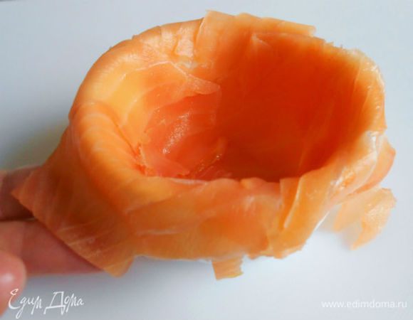 Смажьте маслом маленькие формочки и выложите  тонкими ломтиками нарезанного подкопчённого лосося. Наполните рыбной массой, заверните наверх свисающие ломтики рыбы и охлаждайте 3-4 часа.