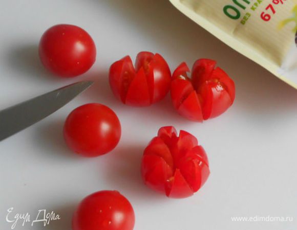 Томаты черри разрезать на 8 сегментов, не прорезая до конца. Расправить "лепестки" и заполнить середину острым хреном.