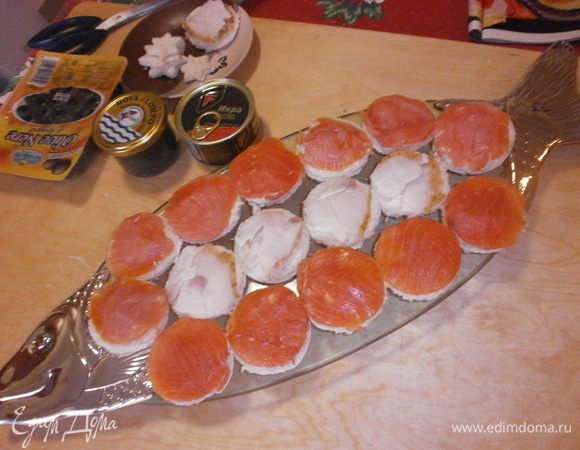 Каждый диск хлеба намазать ароматным маслом и уложить сверху диск рыбы. Будет намного эффктнее, если использовать разные типы рыбы, например осётр, лосось, форель.Выложить канапе на блюдо. Край выложить тонко нарезанными дольками лимона.