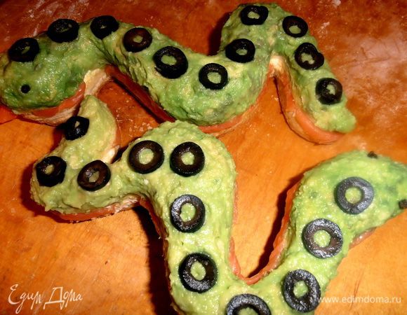 Колечки оливок укладываем на спинки змеек.