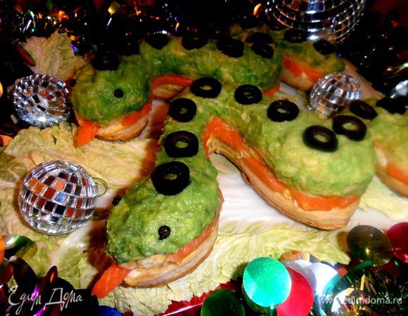 Готовим основу для блюда. На плоскую тарелку или доску укладываем листья салата и кладём на них осторожно змеек.