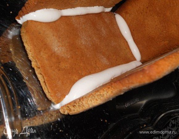 Когда пряники остыли, собираем домик, края соединения смазывать айсингом и скреплять между собой, дать им немного подсохнуть и затем скрепляем следующие края и так дальше, потом чуть подсушить и делать крышу, затем домик оставить сушить на полчасика, а оставшийся айсинг поставить пока в холодильник. Также можно клеить карамелью - то есть растопить сахар и клеить, но если выбирать этот способ, нужно очень быстро все клеить, так как карамель быстро застывает.