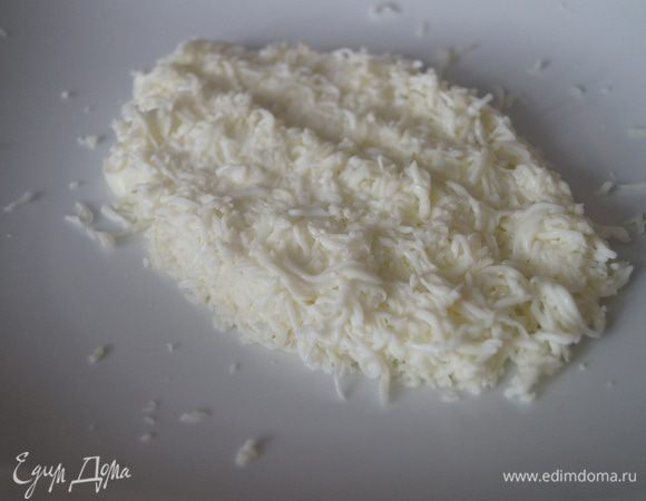 Вареные яйца разделяем на белки и желтки. Белки трем на мелкой терке и выкладываем на блюдо, в котором будем подавать, в форме черепашки, чуть солим и смазываем майонезом